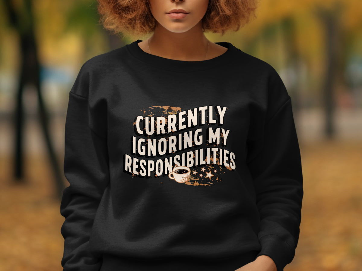 Black crewneck sweatshirt with "Currently Ignoring My Responsibilities" text and coffee cup graphic.