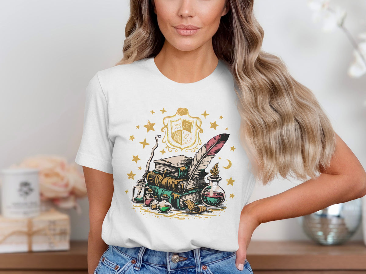 White t-shirt with a design of books, potions, quill, and a coat of arms.