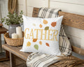 White pillow with "Gather" and falling autumn leaves design.