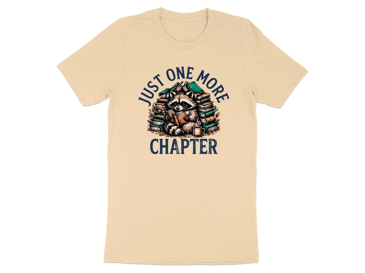 T-shirt with a raccoon reading a book surrounded by books, text "JUST ONE MORE CHAPTER".
