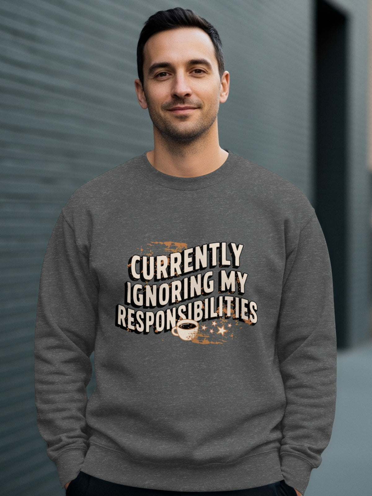 Man in grey sweatshirt with "Currently Ignoring My Responsibilities" text and coffee cup.