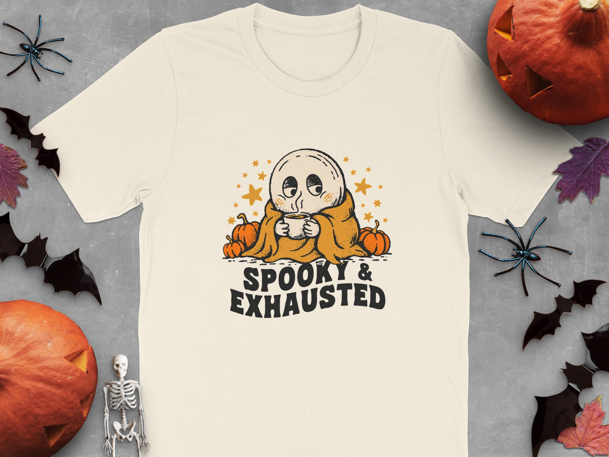 Cream t-shirt with ghost holding coffee, surrounded by pumpkins, stars, and text "SPOOKY & EXHAUSTED".