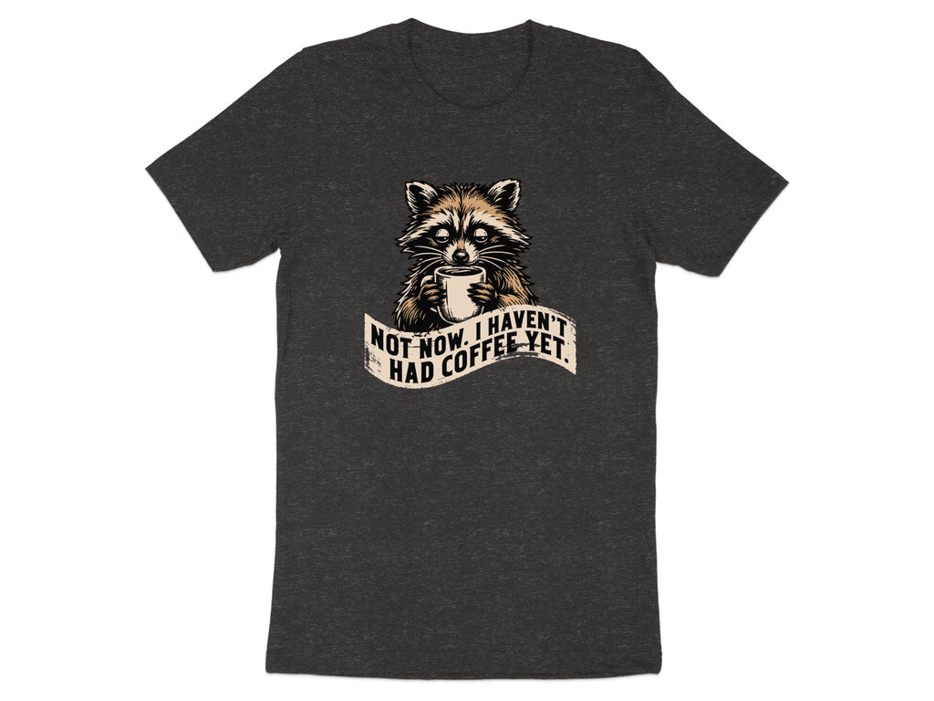 Dark t-shirt with raccoon holding coffee mug and text "Not now. I haven't had coffee yet."