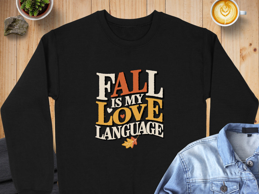 Black sweatshirt with "Fall is my love language" text and autumn leaf graphic.