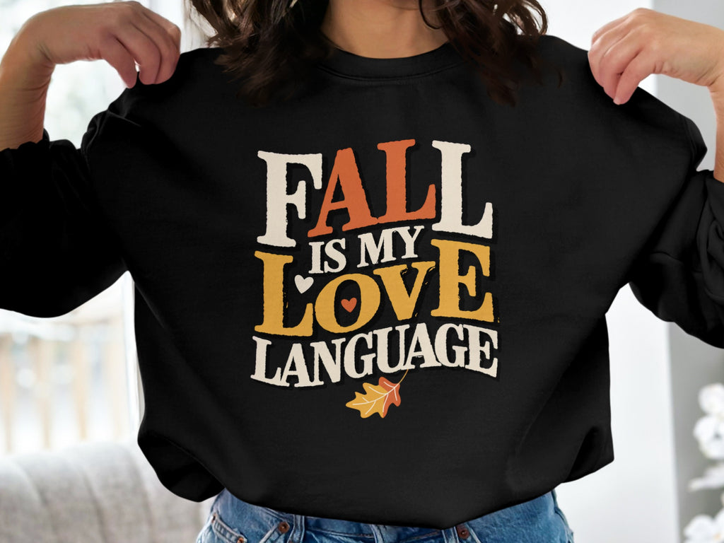 Black sweatshirt with text "FALL IS MY LOVE LANGUAGE" and autumn leaf graphic.