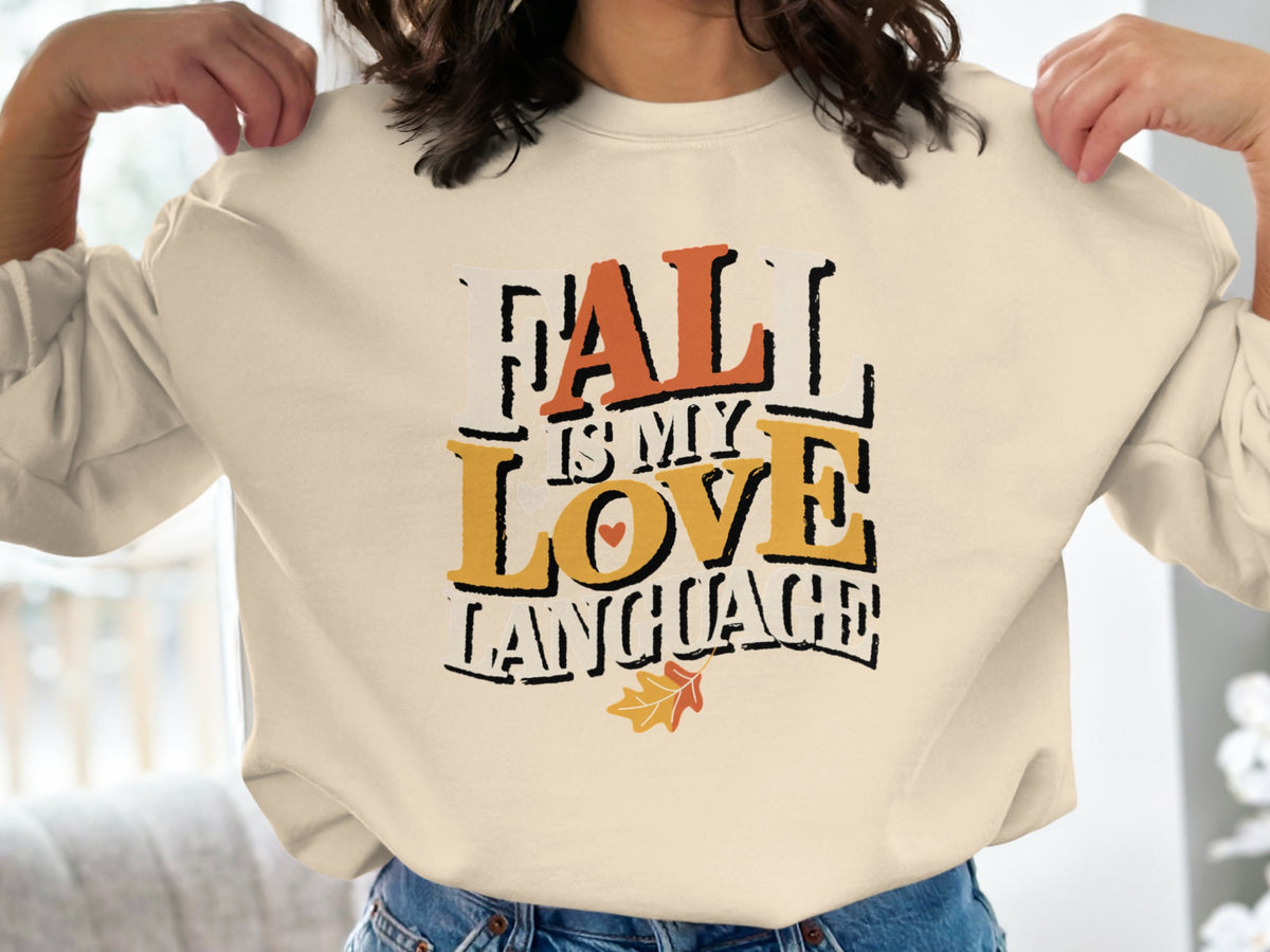 Cream sweatshirt with text "Fall is My Love Language" and fall leaf graphic.