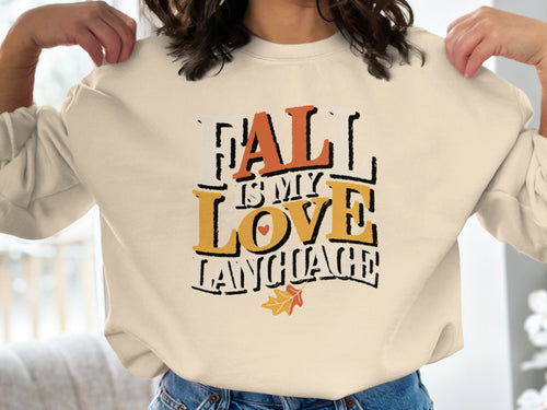 Cream sweatshirt with text "Fall is My Love Language" and fall leaf graphic.
