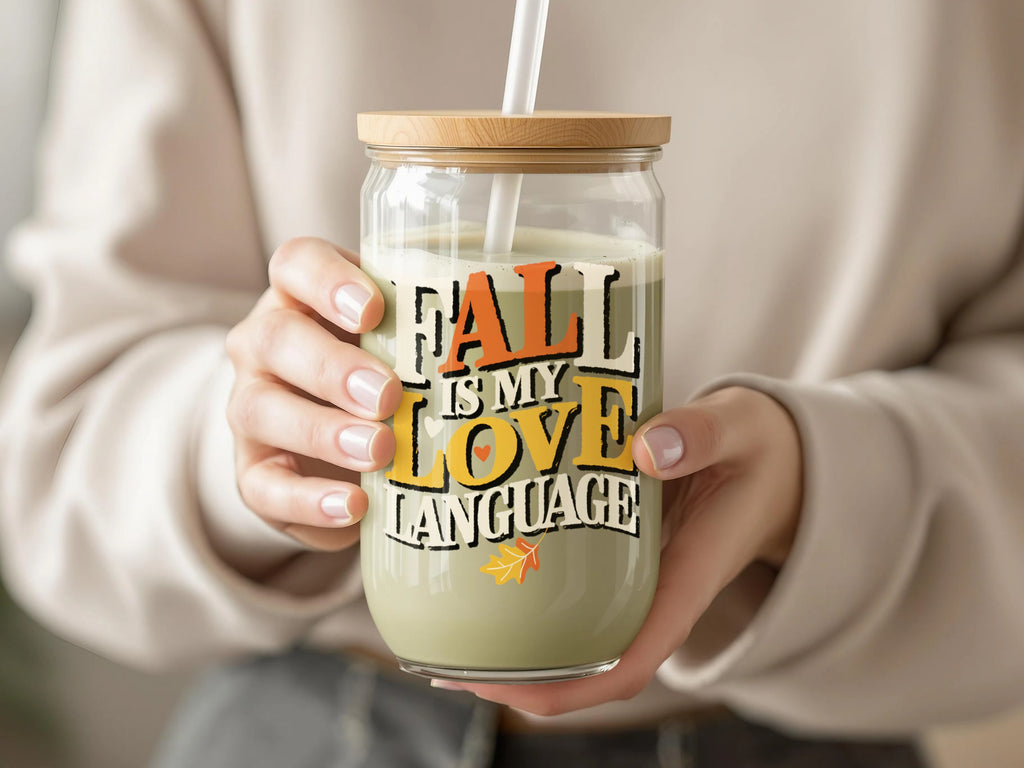 Glass can-shaped tumbler with bamboo lid, straw, and "Fall is my love language" text.