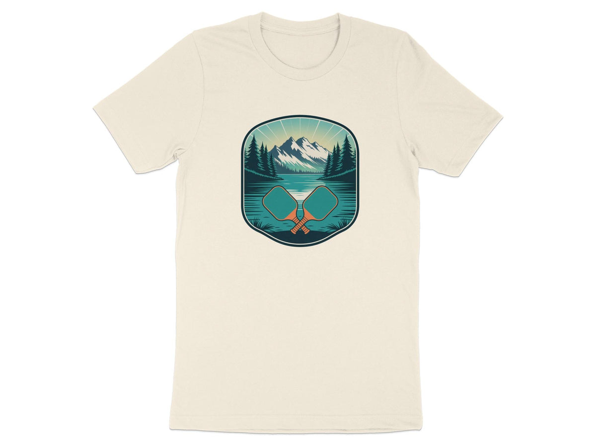 Cream t-shirt with a landscape graphic featuring mountains, lake, trees, and crossed pickleball paddles.